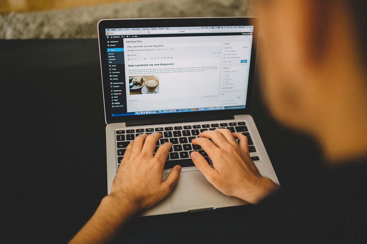 Person typing a blog post on a laptop