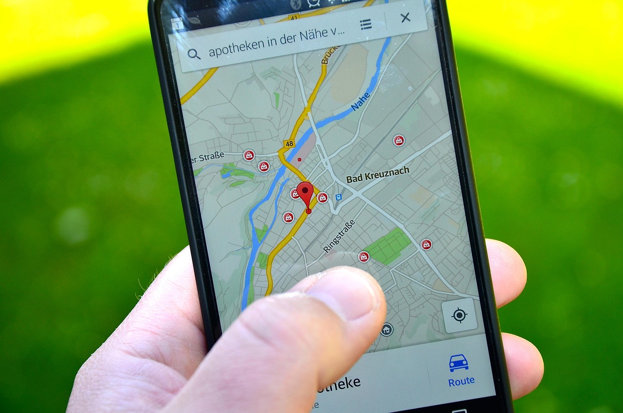 Hand holding a smartphone showing a map app with location pins