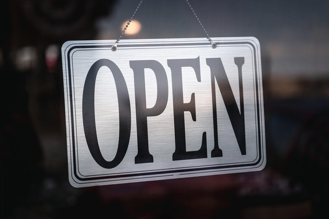 Metal open sign hanging in a shop window
