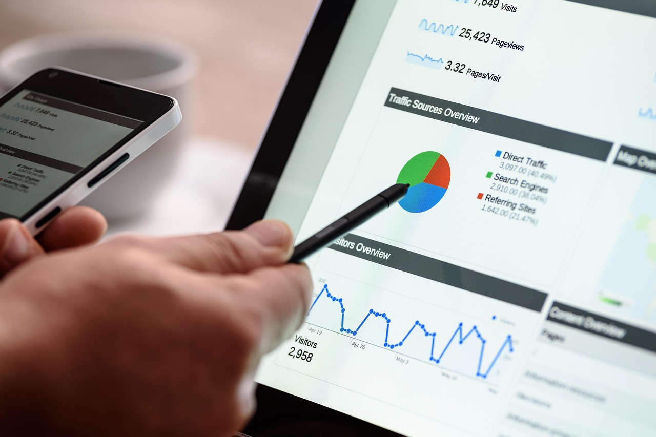 Hand with stylus reviewing a website traffic report on a tablet