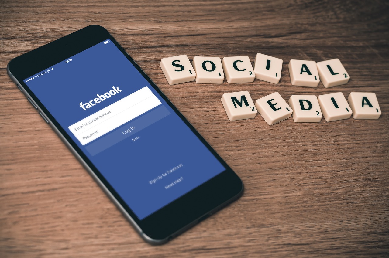 Smartphone showing a social login screen next to letter tiles spelling social media