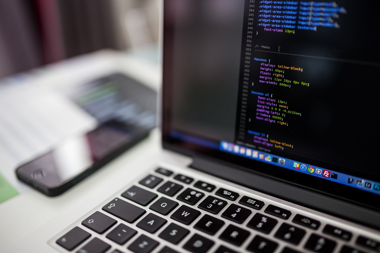 Laptop screen showing website code in a dark editor